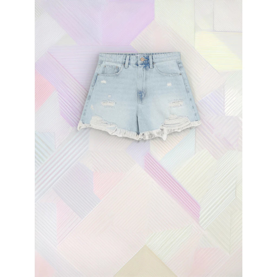 Light wash blue denim shorts with distressed details and a raw frayed hem, laid flat on a pastel geometric patterned background.
