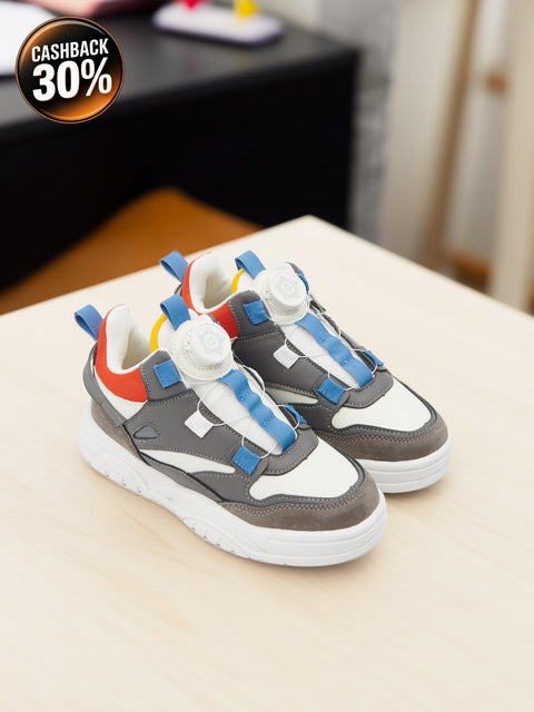 Children's sneakers with colorful laces on a light surface