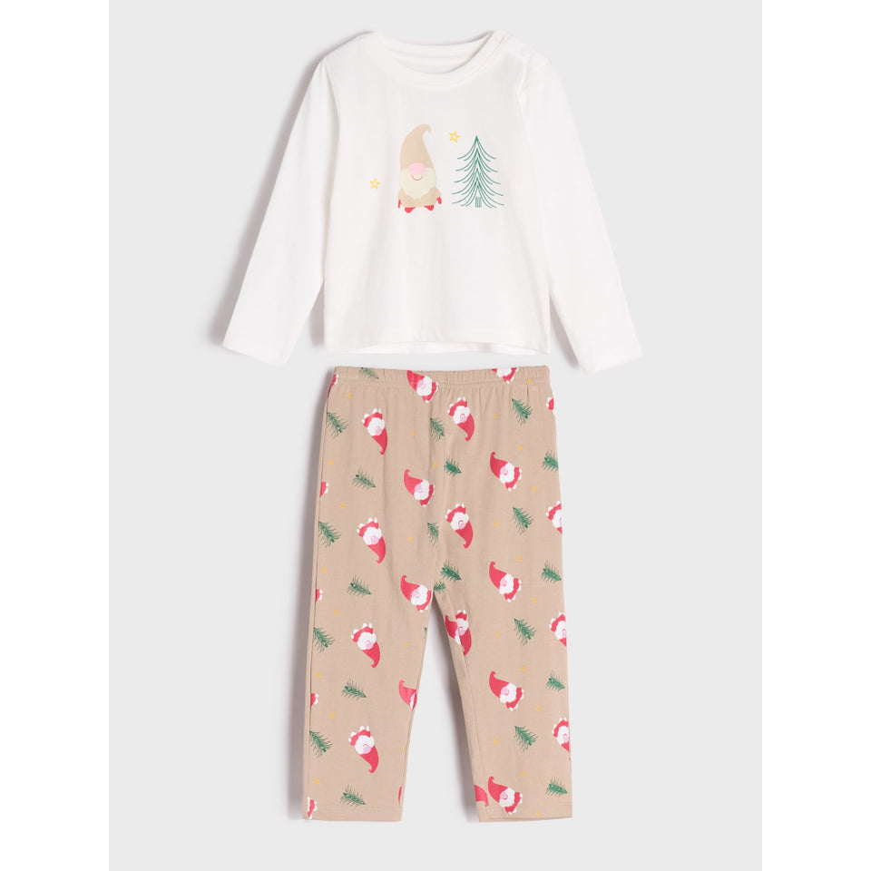 A two-piece children's pajama set featuring a white long-sleeve top with a gnome and Christmas tree graphic, paired with beige pants covered in a red and green gnome pattern, shown on a light gray background.