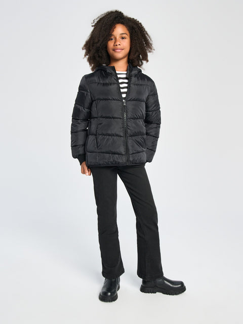 Person wearing a black puffer jacket and pants on a white background
