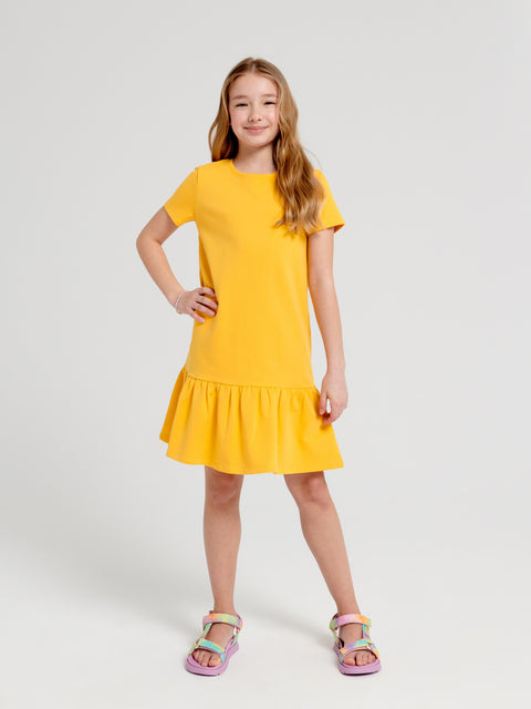 Young girl wearing a yellow dress on a white background