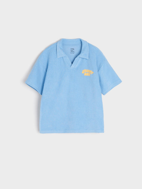 Light blue polo shirt with a yellow logo on a light gray background