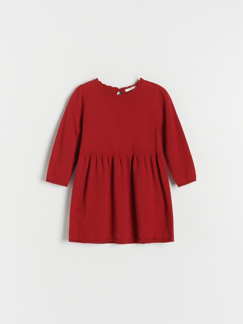Red dress with long sleeves on a light gray background