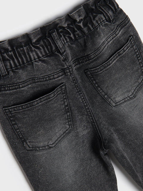 Close-up of black jeans with a white background