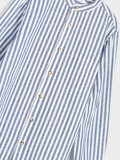 Blue and white striped shirt with gold buttons on a light gray background