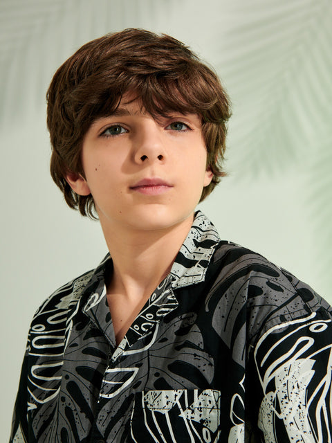 Young boy wearing a patterned shirt against a plain background