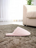 Pink slipper on a fluffy rug in a living room setting