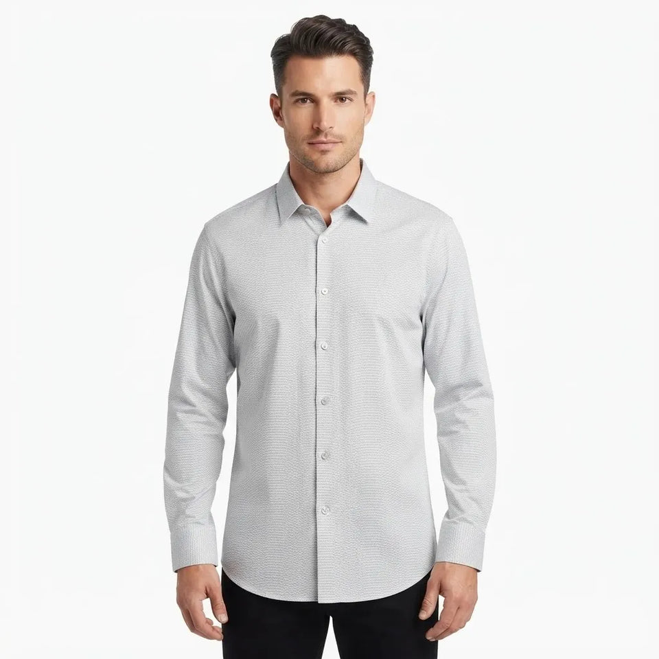 A man wearing a light gray long-sleeve button-down dress shirt with a subtle micro-texture pattern, paired with black pants, against a plain white studio background.