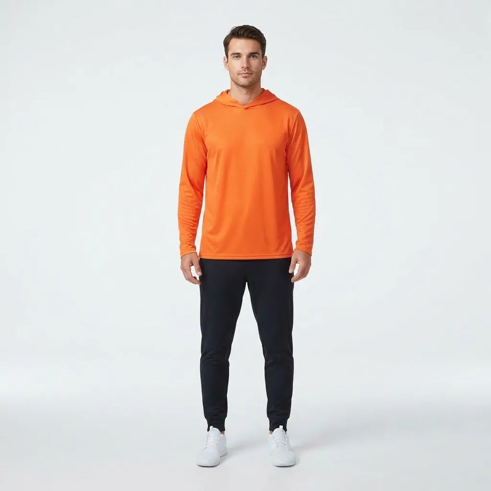 A man modeling a bright orange long-sleeve athletic hoodie with black pants and white sneakers, standing against a light gray studio background.