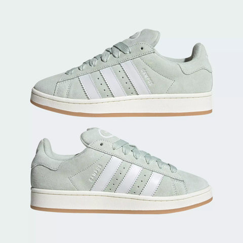 Light green Adidas sneakers with white stripes on a light gray background