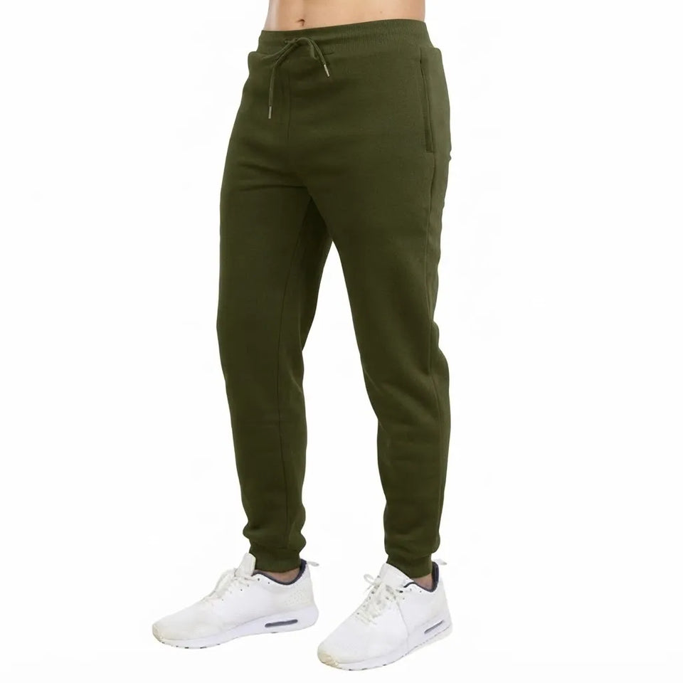 A person wearing olive green jogger sweatpants with a drawstring waist and white sneakers, shown from the waist down on a plain white background.
