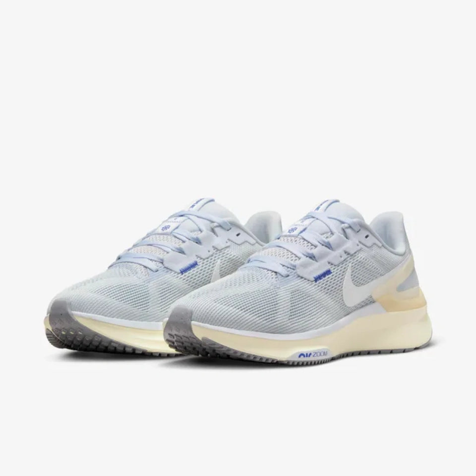 A pair of Nike running shoes in light gray and white with blue accents and a cream-colored midsole, shown against a plain light gray background.