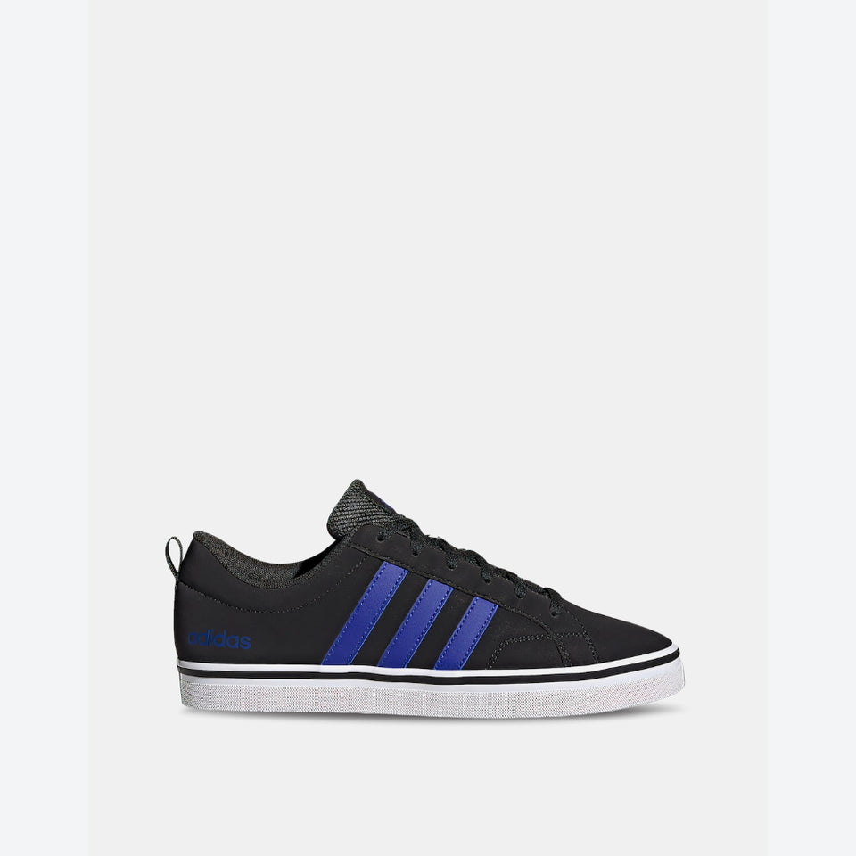 A black Adidas low-top sneaker with three blue stripes on the side, a white rubber sole, and a black laces and tongue, shown against a light gray background.