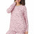 A woman wearing a pink long-sleeve pajama top and matching pants with a gray and black leopard print, shown against a plain white background.