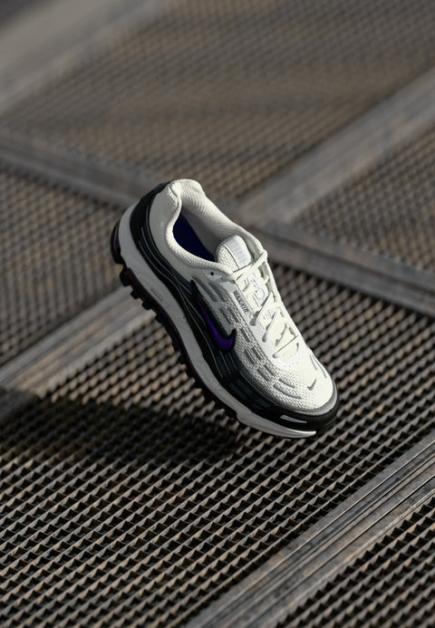 White sneaker with black accents on a metallic surface