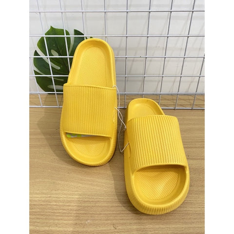 Yellow slippers on a wooden surface with a white mesh background