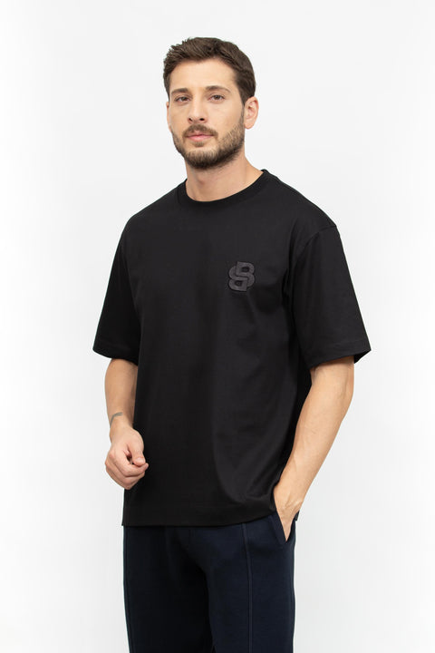 Man wearing a black t-shirt with a logo on a white background