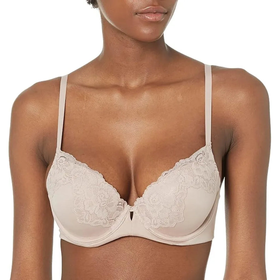 A close-up of a model wearing a light beige wireless bra with floral lace cups and thin shoulder straps against a plain white background.