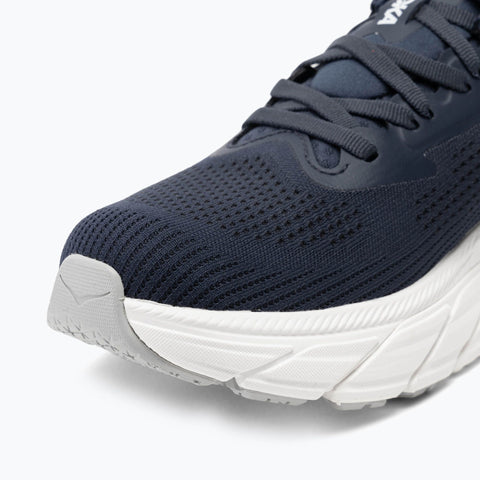 Navy running shoe with white sole on a light gray background