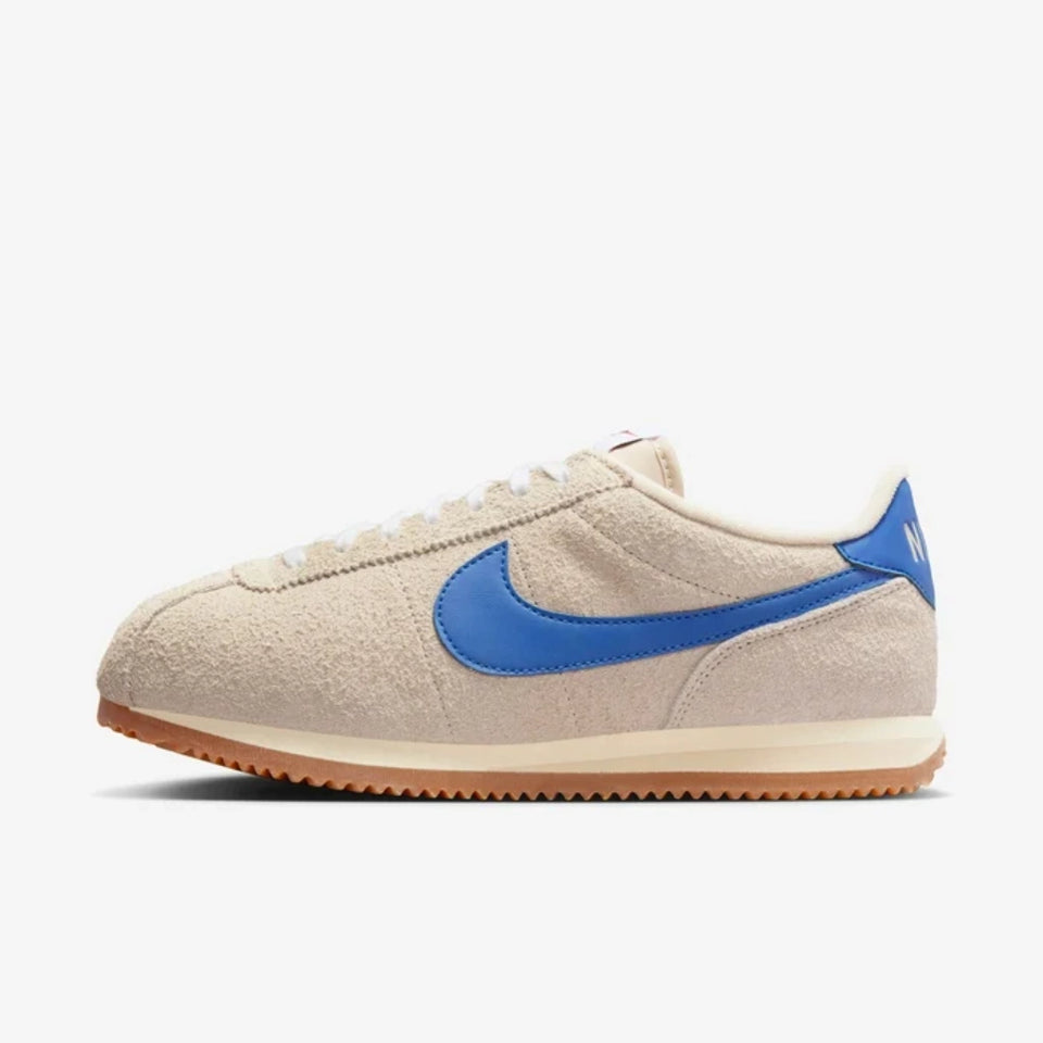 Beige sneaker with blue swoosh logo on a white background