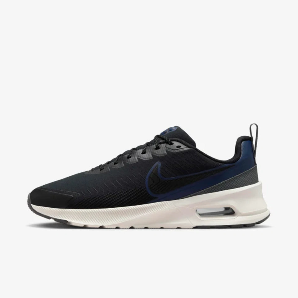 A Nike sneaker in black and navy blue with a white midsole, shown from the side against a light gray background.