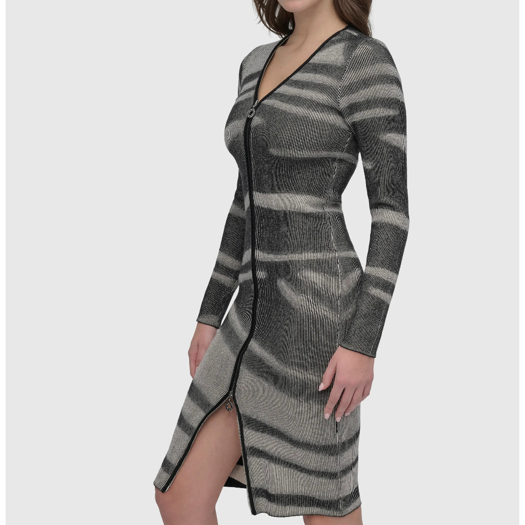 A woman modeling a long-sleeve knit cardigan dress with a gray and black wavy stripe pattern, a front zipper, and a thigh-high slit, paired with black slingback heels against a light gray background.