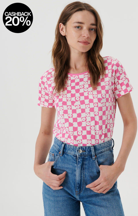 Person wearing a pink and white checkered shirt with blue jeans on a plain background