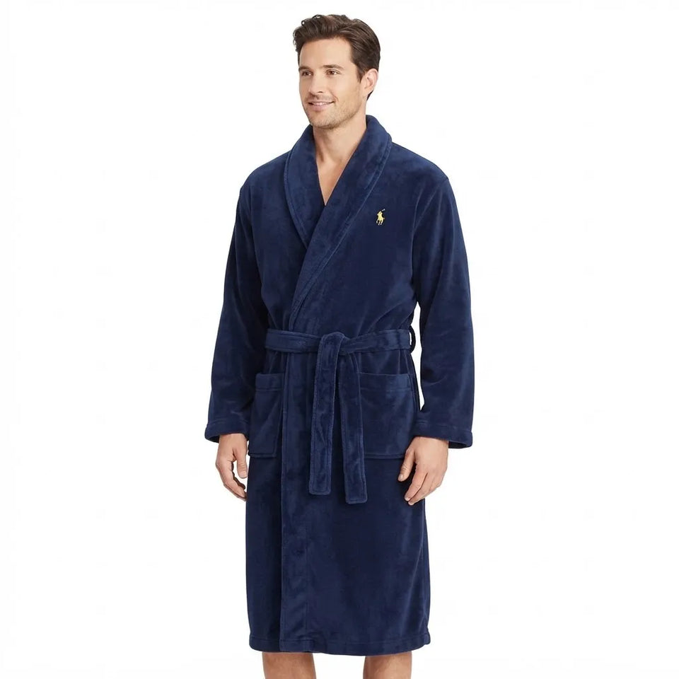 A man wearing a navy blue plush bathrobe with a matching tie belt and a small embroidered polo player logo on the chest, set against a plain white background.