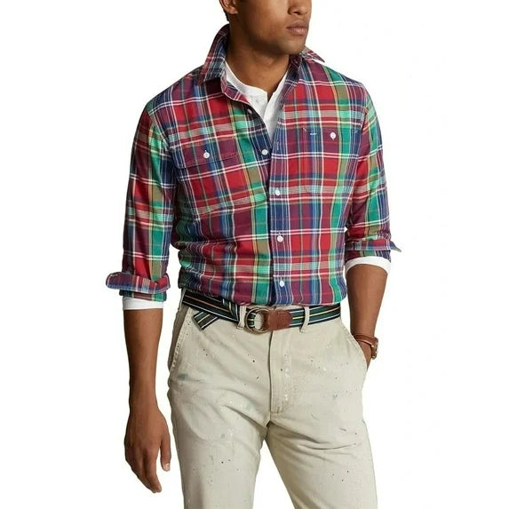 Person wearing a colorful plaid shirt and beige pants on a white background