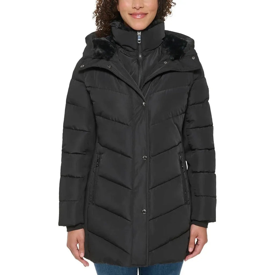 A woman wearing a black hooded puffer coat with faux-fur trim around the collar and hood, shown against a plain white background.