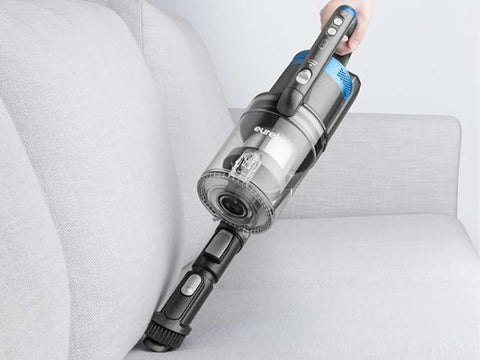 Handheld vacuum cleaner being used on a white sofa