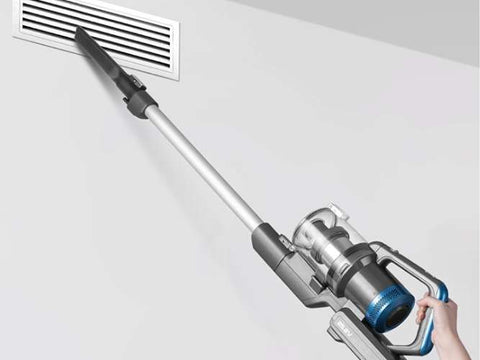 Person using a cordless vacuum cleaner to clean a vent.