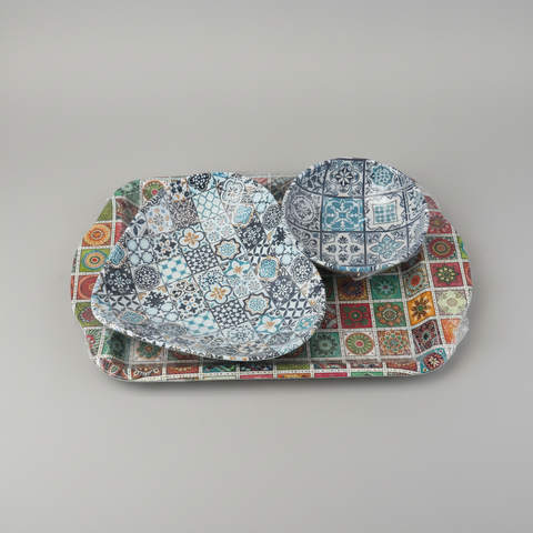 Set of patterned bowls and platter on a gray background