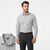 A man modeling a light gray long-sleeve dress shirt with a subtle micro-geometric pattern, paired with dark gray trousers and a brown belt. An inset in the bottom-left corner shows a close-up of the shirt's collar and inner neck label, which reads 'Sutton'.