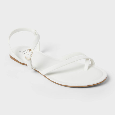 White sandal with criss-cross strap design on a light gray background