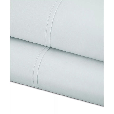 Close-up of light blue bed sheets with a subtle pattern on a white background