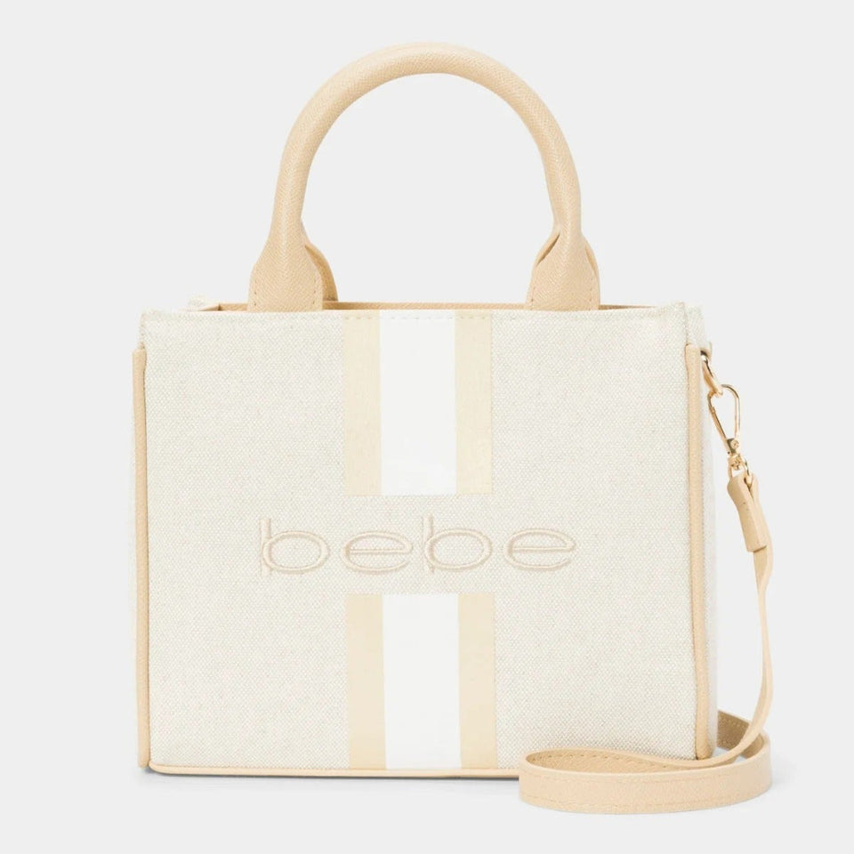 Bebe brand cream canvas tote bag with beige handles and a vertical beige stripe, featuring the embossed 'bebe' logo on the front.