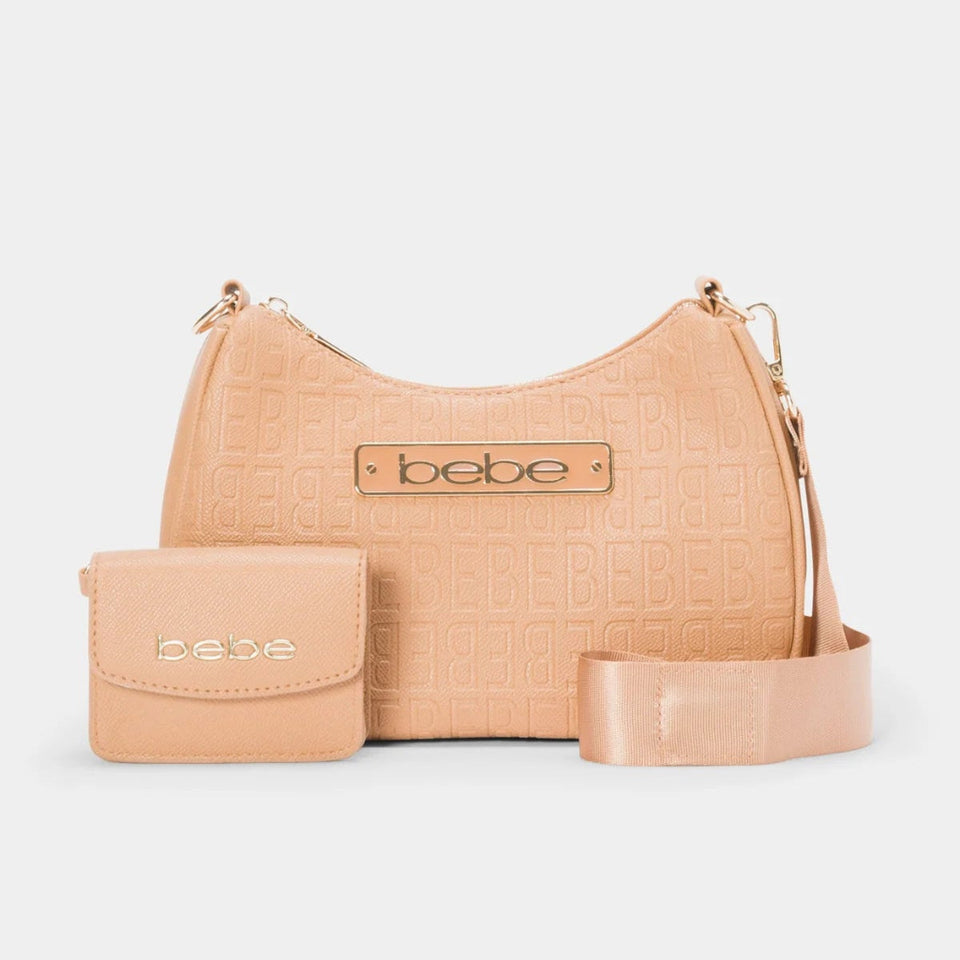 A light peach-beige embossed leather hobo handbag with a matching small crossbody pouch and a wide matching shoulder strap, displayed on a light gray background. The brand name 'bebe' is visible on the front of both the bag and the pouch.