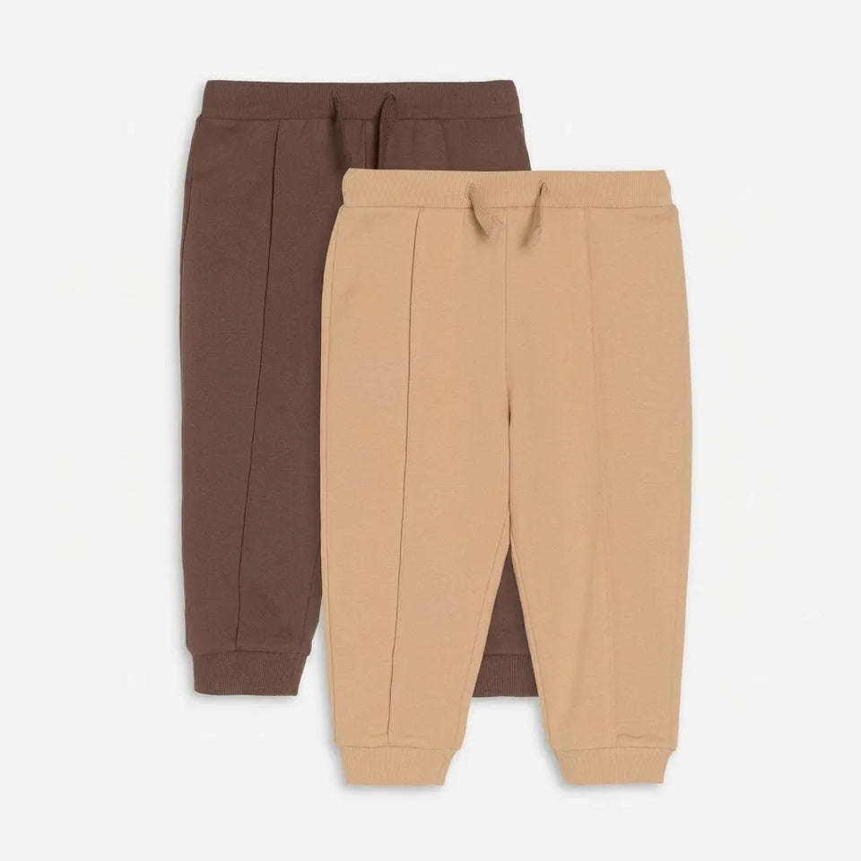 Two pairs of children's jogger sweatpants, one in dark brown and one in tan, displayed flat against a light gray background.