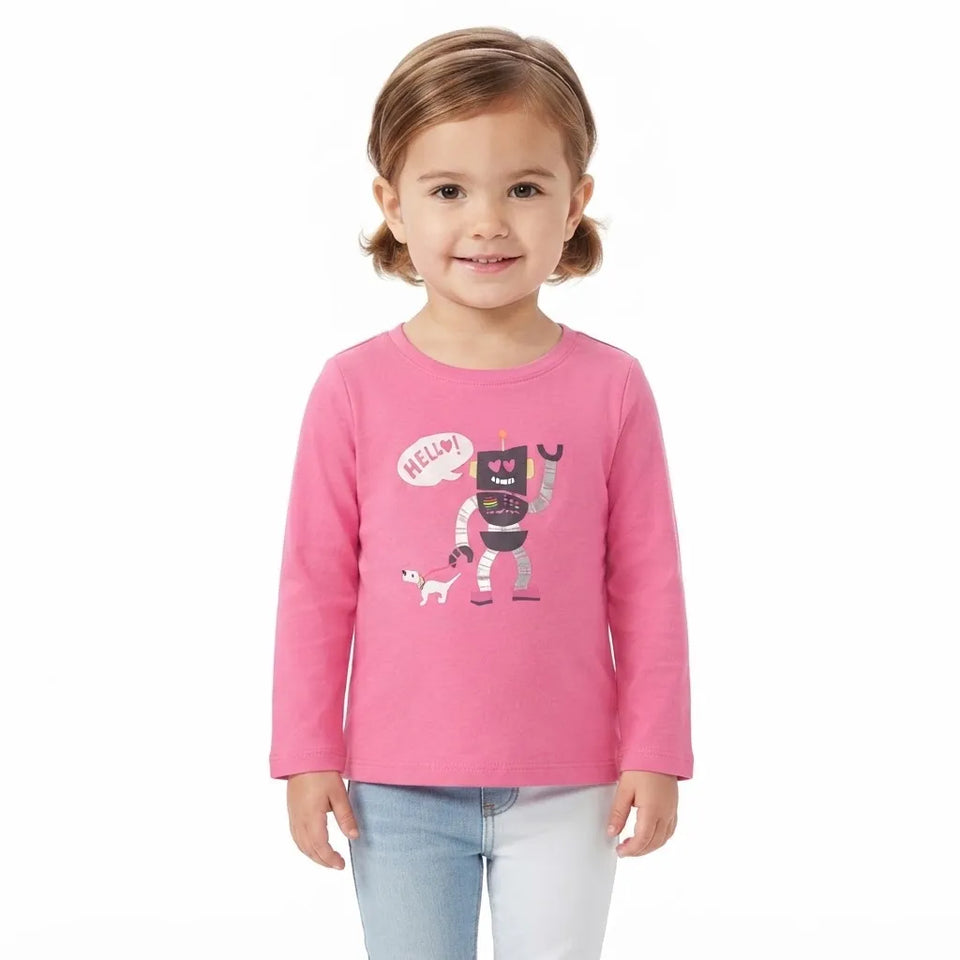 A young girl with light brown hair in a ponytail wearing a pink long-sleeve t-shirt with a cartoon robot and dog graphic, paired with light blue jeans, standing against a plain white background.