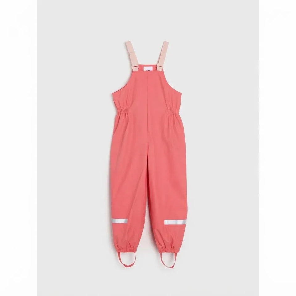A baby's coral pink sleeveless jumpsuit with adjustable shoulder straps, elasticized ankles, and reflective silver stripes on the lower legs, shown against a light gray background.