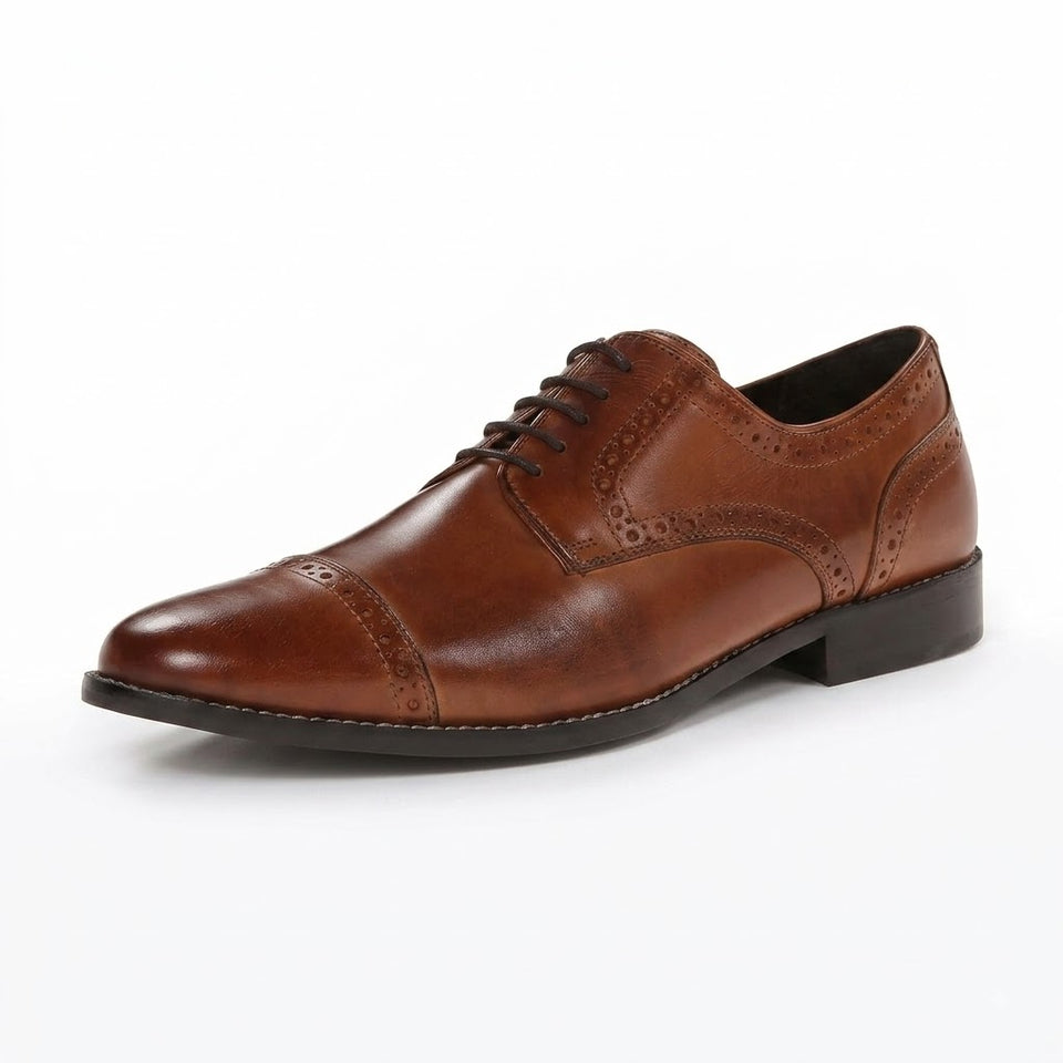 A single brown leather cap-toe oxford shoe with brogue detailing and laces, shown from a three-quarters angle on a white background.