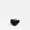 A single black leather slide sandal with a large bow on the toe strap, photographed against a seamless white background.