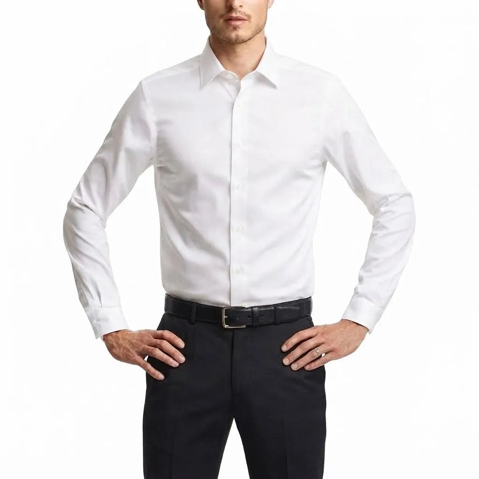 A man wearing a crisp white long-sleeve dress shirt tucked into dark trousers with a black belt, photographed against a clean white studio background.
