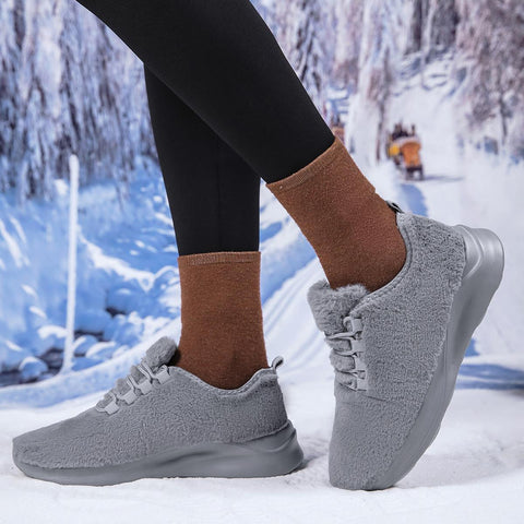 Gray sneakers worn with brown socks in a snowy outdoor setting