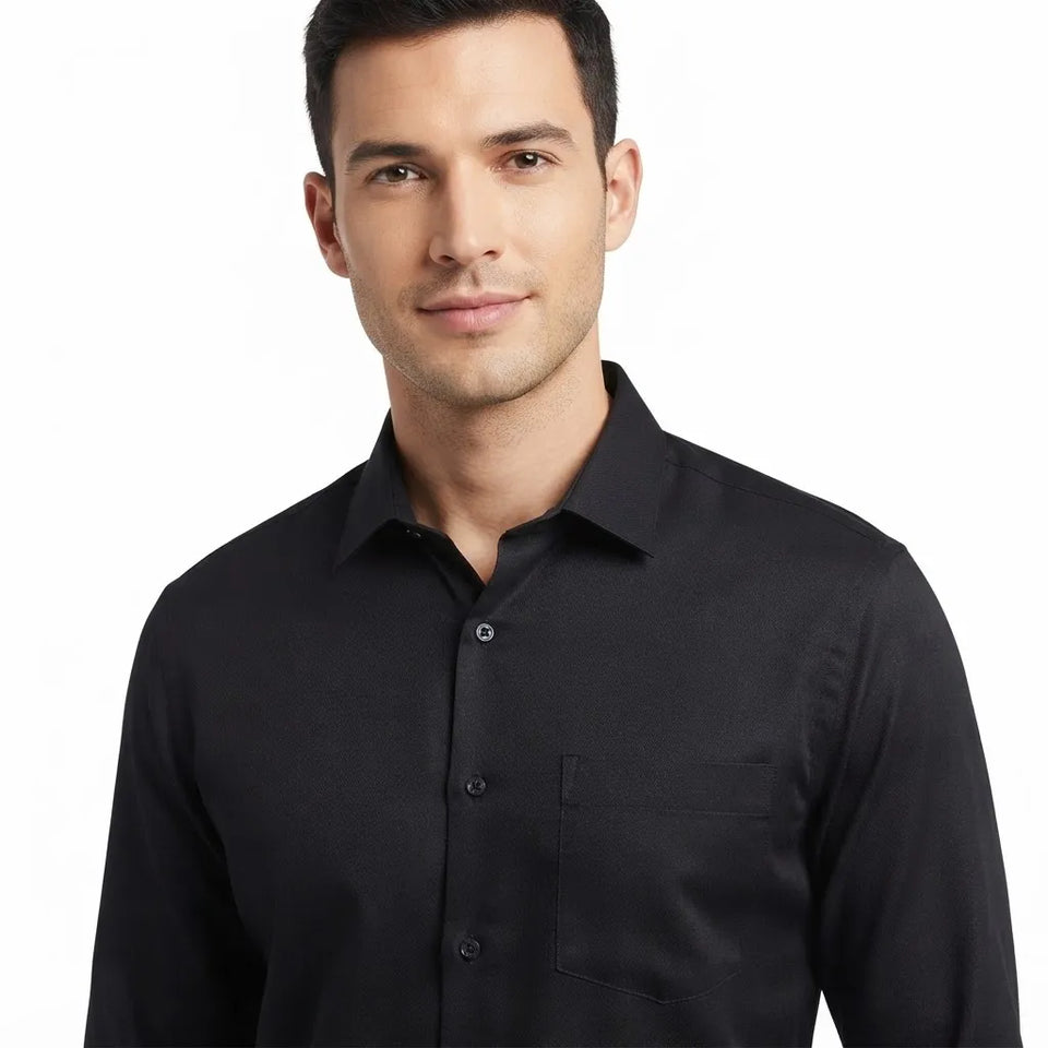 A man wearing a black long-sleeve button-down shirt, shown from the chest up against a plain white background.