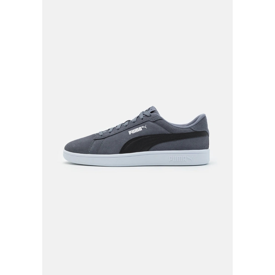 A Puma Suede Classic sneaker in dark gray suede with a black synthetic side stripe and a light gray sole, shown from the side on a light gray background.