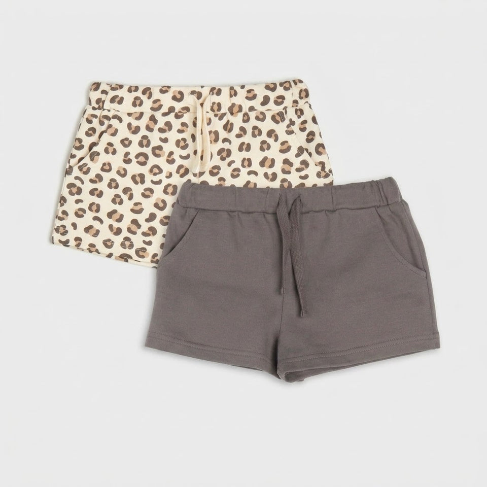 Two pairs of women's drawstring shorts laid flat on a light gray background. The front pair is solid taupe-brown, and the back pair is cream with a brown leopard print.