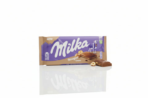 Milka chocolate bar packaging held by a person in a store setting