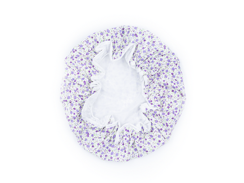 White shower cap with purple floral pattern on a white background